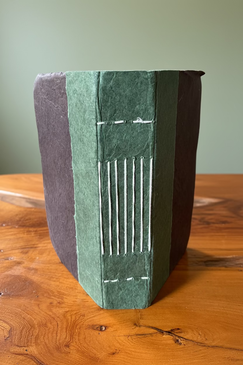 Book with green and brown cover on a wooden surface