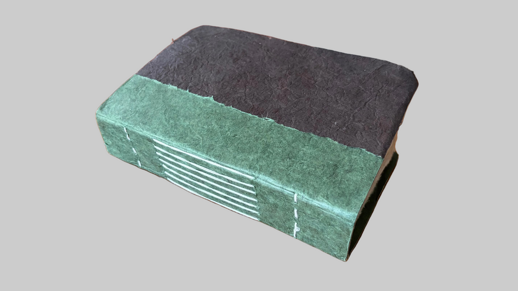 Book with green and brown cover on a wooden surface